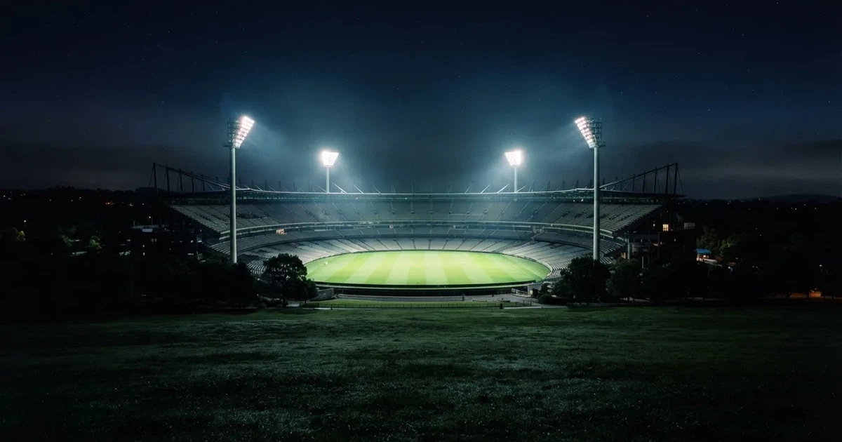 Ein Stadion bei Nacht unter Flutlicht aus der Ferne gesehen, der Rasen ist hell erleuchtet, keine erkennbaren Personen.
